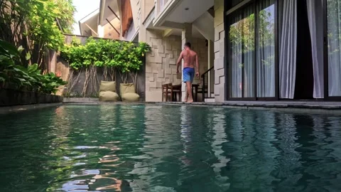 Man relaxing poolside at luxury private villa resort Vidéo 340848008