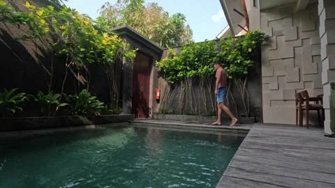 Man relaxing poolside at luxury private villa resort Stock Footage 341515879