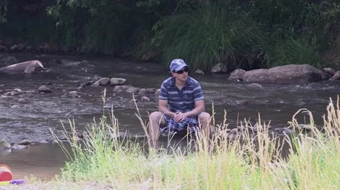 Man relaxing in river bed Stock Footage 43386557