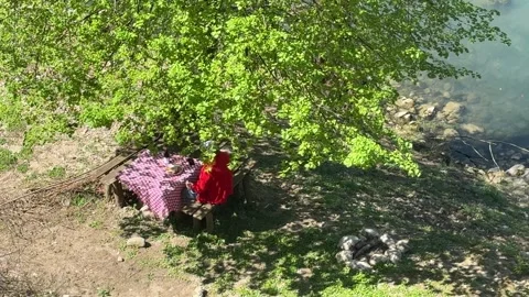 Man Relaxing at Rustic Picnic Table Under Tree Near River, Countryside Slow Livi 動画素材 333523046