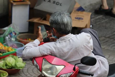 Man Relaxing on Scooter While Using Smartphone Foto stock