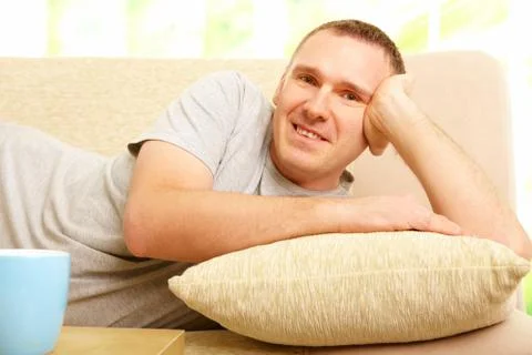 Man relaxing on sofa with cup Stock Photos