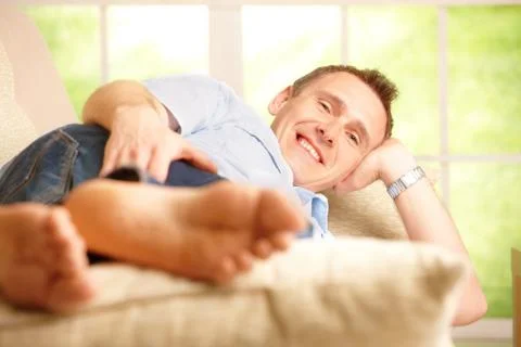 Man relaxing on sofa Stock Photos