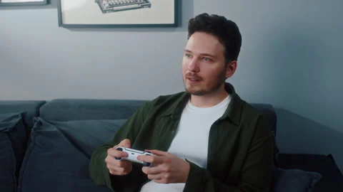 Man relaxing on sofa playing video game at home Vídeos de archivo 319545015