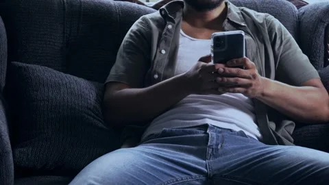 Man relaxing on sofa using smartphone, health and technology concerns Video stock 317056188
