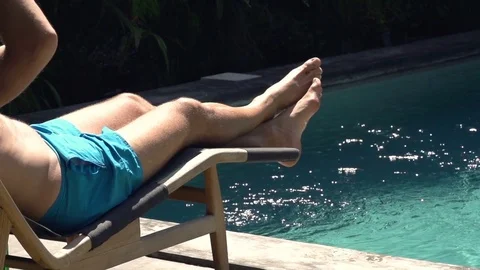 Man relaxing, sunbathing on sunbed lying by pool, super slow motion 240fps Stock Footage 79162826