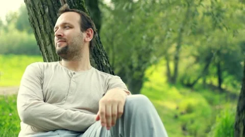 Man relaxing by the tree in the park Video stock 8579506
