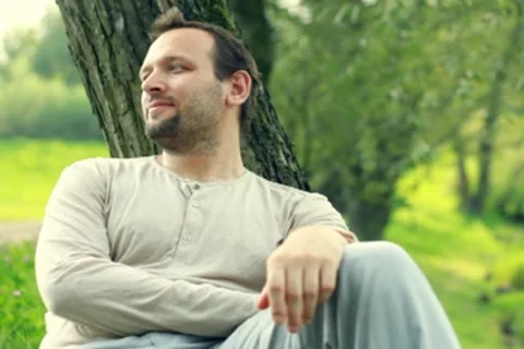 Man relaxing by the tree in the park Stock Footage 8579515