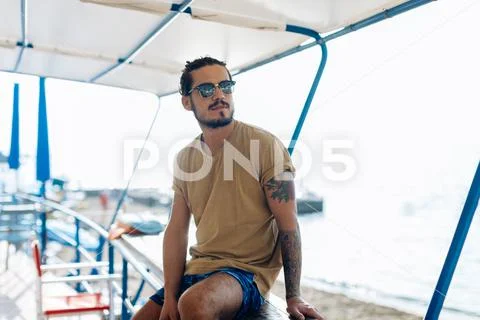 Man relaxing under canopy at sea, Livorno, Italy Stock Photos