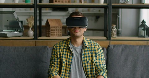 Man is relaxing in virtual reality headset at home Video stock 114889661