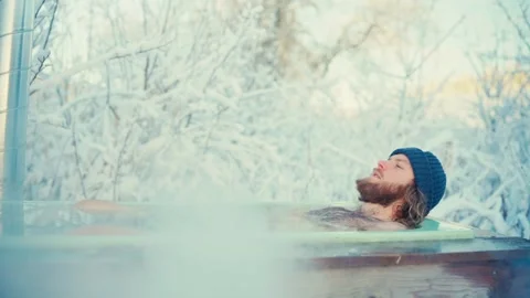 A Man is Relaxing While Soaked in a Hot Tub With Steaming Smoke During the Stock Footage 295764608