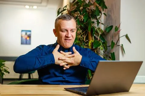 Man Relieving Stress with a Stretch at Work Desk Stock Photos