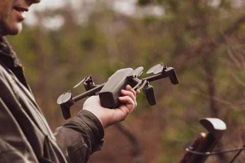 Man with remote control cell phone hold drone. Stock Photos