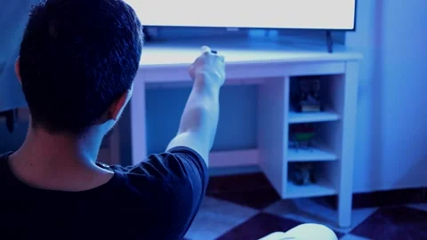 Man with remote control changing channels on television Stock Footage 289992417