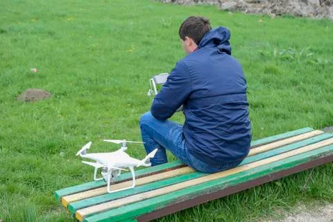 A man with a remote control drone in his hands is sitting Stock Photos
