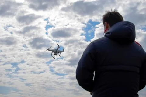 A man with a remote control in his hands. Controlling the flight of the dro.. Stock Photos