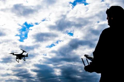 A man with a remote control in his hands. Controlling the flight of the dro.. Stock Photos