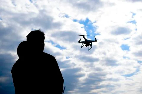 A man with a remote control in his hands. Controlling the flight of the dro.. Stock Photos