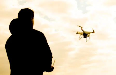 A man with a remote control in his hands. Controlling the flight of the dro.. Stock Photos