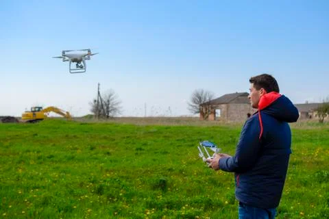 A man with a remote control in his hands. Flight control of the drone. Phanto Stock Photos