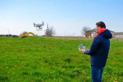 A man with a remote control in his hands. Flight control of the drone. Phanto Stock Photos