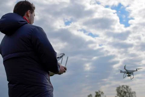 A man with a remote control in his hands. Controlling the flight of the drone Stock Photos
