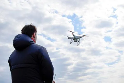 A man with a remote control in his hands. Controlling the flight of the drone Stock Photos