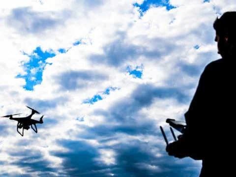 A man with a remote control in his hands. Controlling the flight of the drone Stock Photos
