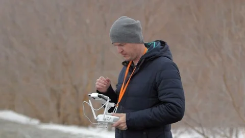 A man with a remote control warms his hands with breathing. Stock Footage 69960462