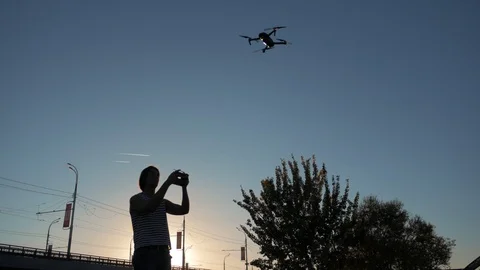 Man with remote controller operating flying drone or quad copter - modern small Stock Footage 97069484