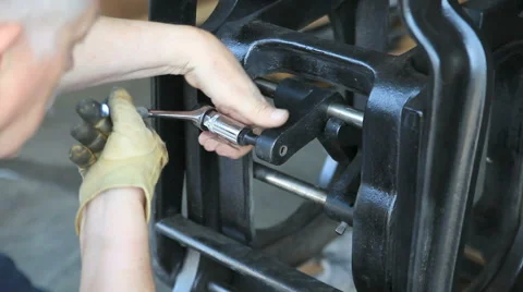 Man removes bolt from letterpress machine Stock Footage 60110915