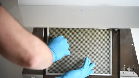 A man removes a cleaning filter from a range hood. Stock Footage 299721429