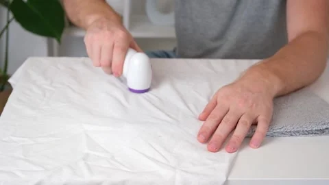 Man removes fabric pills using lint shaver. Stock Footage 201517350