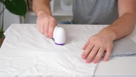 Man removes fabric pills using lint shaver. Stock Footage 203851895