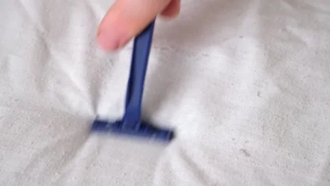 A man removes fabric pills using disposable shaving machine. A razor for Stock Footage 203852168