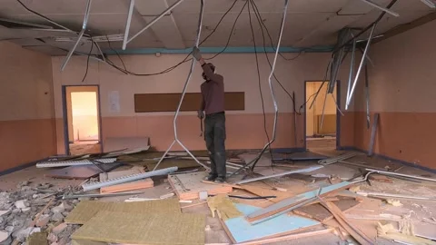 A Man Removes The False Ceiling Of A Building Under Demolition - static Stock Footage 157463970