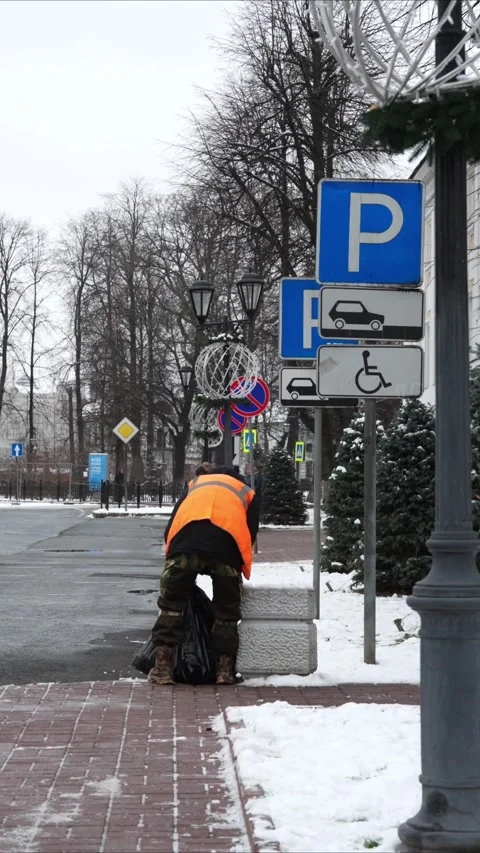 A man removes garbage from an urn Stockbeeldmateriaal 293718232