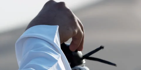 A man removes a head cap from a falcon. Stock Footage 46871184
