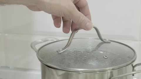 Man removes lid from pot of boiling water 動画素材 276775249