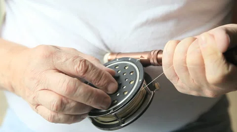 Man removes line spool from fly fishing reel Stock Footage 54803614