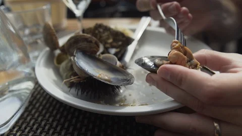Man removes a mussel from its shell with a fork, sprinkles fresh lemon juice Stock Footage 106247109