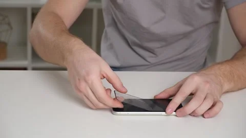 Man removes old cracked protective glass from phone. Broken glass iPhone XR Stock Footage 237858583
