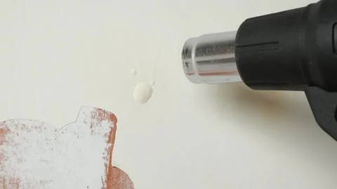A man removes old white enamel paint from wooden door with a construction hair Stock Footage 176535590