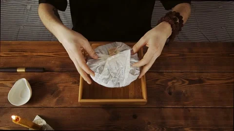 A man removes the outer packaging of Chinese pressed tea Stock Footage 139332027