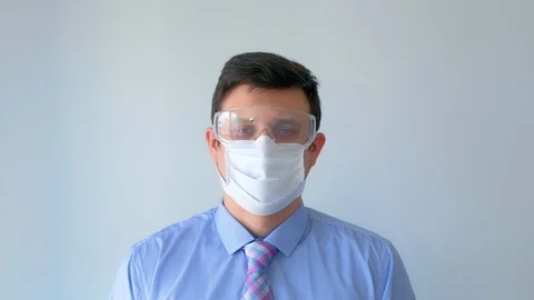 Man removes protective mask and glasses, making deep free breath, coronavirus. Stock Footage 129137307