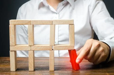 The man removes the red structural element, which will collapse. Incompeten.. Stock Photos