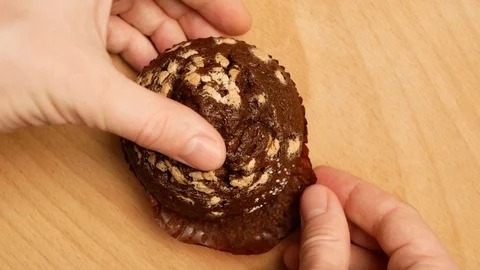 Man removes a wrapper with cupcake. Stock Footage 107730276