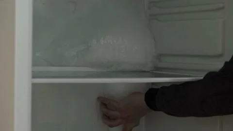 A man removing ice from refrigerator 库存影片 168571628