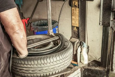 Man removing leads from wheel using electric tools in a workshop Stock Photos