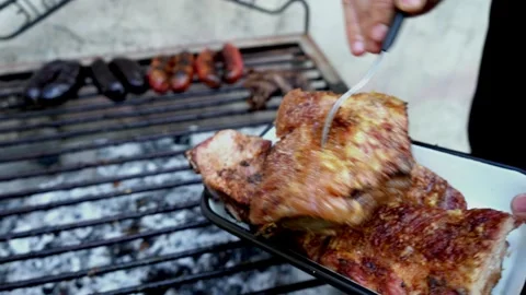 Man removing leftover pieces of meat after a barbecue. Stock Footage 293367425